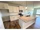 Modern kitchen with white cabinetry, granite countertops, island, and stainless steel appliances at 60 Falls Of The Cape Dr, Lillington, NC 27546