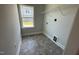 A clean laundry room with grey floors, a window, a wire rack, and light grey walls at 60 Falls Of The Cape Dr, Lillington, NC 27546