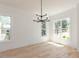 Bright dining room with hardwood floors, modern chandelier, and large windows at 103 Brandy Ml, Pittsboro, NC 27312