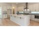 Bright kitchen features white cabinets, stainless steel appliances, and large center island with a black faucet at 103 Brandy Ml, Pittsboro, NC 27312