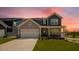 Stunning home with a manicured lawn, a two-car garage, stone accents, and a covered front porch at 657 Sun Meadow Dr, Wake Forest, NC 27587