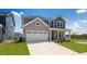 Lovely home with a well-manicured lawn, a two-car garage, and stone accents on the facade at 657 Sun Meadow Dr, Wake Forest, NC 27587