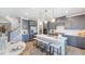 Stylish kitchen with gray cabinetry, a center island with seating, and modern lighting at 657 Sun Meadow Dr, Wake Forest, NC 27587