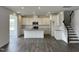 Bright kitchen featuring white cabinets, stainless steel appliances, an island, and hardwood floors at 657 Sun Meadow Dr, Wake Forest, NC 27587