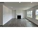 Open living room with hardwood floors, a cozy fireplace, and plenty of natural light from large windows at 657 Sun Meadow Dr, Wake Forest, NC 27587