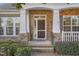 Welcoming front entrance with brick and stone accents, complemented by white pillars and lush landscaping at 719 Allforth Pl, Cary, NC 27519