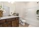 Clean bathroom with a dark wood vanity, tiled floors, and a shower-tub combo at 3408 Cross Timber Ln, Raleigh, NC 27603