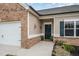 Inviting home entrance with brick accents, a dark front door, and a well-maintained landscaped garden at 3408 Cross Timber Ln, Raleigh, NC 27603