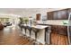 Kitchen island with bar stool seating, white countertops, dark cabinets, and view to the living room at 3408 Cross Timber Ln, Raleigh, NC 27603