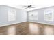 Bright bedroom with wood floors, ceiling fan, and multiple windows at 6416 Truxton Ln, Raleigh, NC 27616