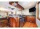 Basement bar features wooden cabinets, granite countertops, recessed lighting, and a beverage fridge at 106 Springbrook Pl, Cary, NC 27518
