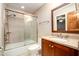 Bathroom features shower-tub combo, tile surround, sliding door, and wood vanity with stone countertop at 106 Springbrook Pl, Cary, NC 27518