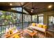 Covered back porch with wood floors, ceiling fan, and wooded views at 106 Springbrook Pl, Cary, NC 27518