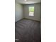 Bedroom with carpet, featuring a bright window offering serene outdoor views and natural light at 1103 Mountain Crown St, Durham, NC 27703