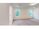 Bright bedroom with carpeted floors, two windows, and fresh paint at 1216 Dimaggio Dr # 29, Raleigh, NC 27616
