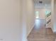 Hallway featuring hardwood flooring and stairs with wood railing leading to upper levels at 1216 Dimaggio Dr # 29, Raleigh, NC 27616