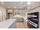 Open concept kitchen with gray cabinets, stainless steel appliances, island, and wood floors at 1216 Dimaggio Dr # 29, Raleigh, NC 27616