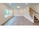 Spacious living room with wood flooring, bright windows, and staircase access at 1216 Dimaggio Dr # 29, Raleigh, NC 27616