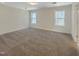Bright bedroom featuring neutral carpet and two windows offering natural light at 1221 Dimaggio Dr # 10, Raleigh, NC 27616