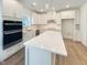 Modern kitchen featuring stainless steel appliances, white cabinets, and a quartz island at 1221 Dimaggio Dr # 10, Raleigh, NC 27616