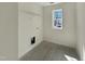 Bright laundry room with built-in shelving, window, and tile floors at 1221 Dimaggio Dr # 10, Raleigh, NC 27616
