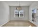 Bright dining area featuring stylish lighting and access to the outdoor space through a glass door at 128 Santa Rosa Way, Four Oaks, NC 27524