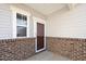Charming front porch with brick accents, a storm door, and a window at 2117 Attend Xing, Fuquay Varina, NC 27526