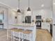 Stylish kitchen featuring a granite island with seating, stainless steel appliances, and modern pendant lighting at 3217 Satterwhite Point Rd, Henderson, NC 27537