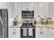 Modern kitchen featuring white cabinets, granite countertops, and stainless steel appliances at 3217 Satterwhite Point Rd, Henderson, NC 27537