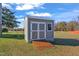 New backyard shed, featuring double doors, a ramp and window in a large yard at 3217 Satterwhite Point Rd, Henderson, NC 27537