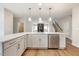 Modern white kitchen with a large island, stainless steel appliances, and hardwood floors at 5375 Salem Woods Dr # Sw 11, Graham, NC 27253