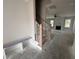 Unfinished staircase and bench in foyer leading to a spacious living room with fireplace and plenty of natural light at 103 Roma Gora Ct, Princeton, NC 27569