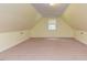 Bedroom featuring sloped ceilings, carpet, and a large window at 178 Paceville Rd, Selma, NC 27576