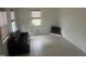 Bright living room with tile floors, a black leather sofa, and natural light at 178 Paceville Rd, Selma, NC 27576