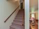 Carpeted staircase with wooden handrail, leading to the upper level of the home at 178 Paceville Rd, Selma, NC 27576