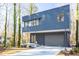 Modern home with cantilevered design, gray siding, and large windows offering an abundance of natural light at 1208 Wimbleton Dr, Raleigh, NC 27609