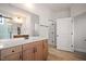 Vanity with wood cabinets, quartz countertop, and an attached bathroom at 1221 Cricket St, Elon, NC 27244