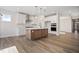 Open kitchen boasts an island, white cabinets, and hardwood floors at 1221 Cricket St, Elon, NC 27244