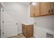 Laundry room with wood cabinets and additional storage at 1221 Cricket St, Elon, NC 27244