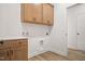 Laundry room with wood cabinets, quartz countertop, and built-in shelving at 1221 Cricket St, Elon, NC 27244