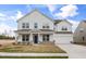 Attractive two-story home featuring a charming covered porch and well-manicured lawn at 1233 Cricket St, Elon, NC 27244