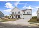 Beautiful white two-story home with a covered front porch and a two-car garage at 1233 Cricket St, Elon, NC 27244