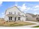 Charming two-story white home with a covered porch, complemented by a neatly landscaped lawn at 1233 Cricket St, Elon, NC 27244