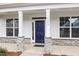 Welcoming front entrance with a navy blue door framed by stone-accented columns and bright windows at 1233 Cricket St, Elon, NC 27244