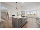 Kitchen island with quartz countertop, pendant lighting, and an open view to the living room and fireplace at 1233 Cricket St, Elon, NC 27244