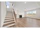 Living room view featuring a staircase and fireplace, illuminated by natural light through large windows at 1233 Cricket St, Elon, NC 27244