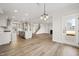 Open floorplan with kitchen island, living room fireplace, and staircase with hardwood floors throughout at 1233 Cricket St, Elon, NC 27244