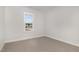 Empty bedroom with neutral carpet and a window overlooking the neighborhood at 613 Tuscany Cir, Princeton, NC 27569