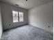 Unfurnished bedroom with large window and concrete flooring at 702 Tuscany Cir, Princeton, NC 27569