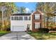 Charming two-story home featuring a brick accent, white siding, black shutters, and an attached two-car garage at 104 Full Moon Ct, Garner, NC 27529